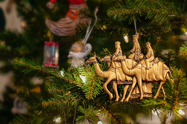 Figura de los tres reyes magos colgada en un árbol de Navidad