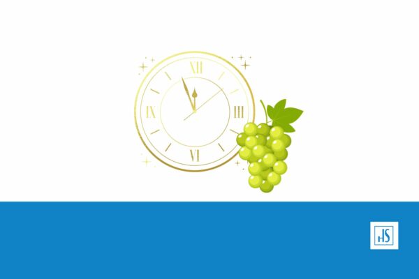 Un racimo de uvas y un reloj representando el fin de año en España.