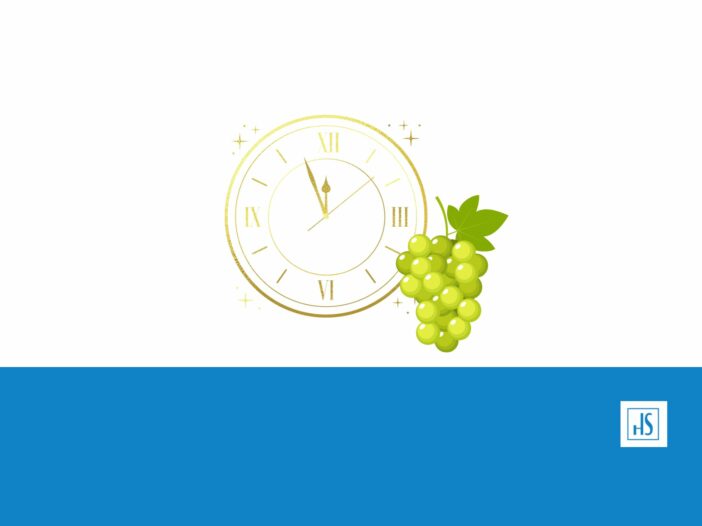 Un racimo de uvas y un reloj representando el fin de año en España.